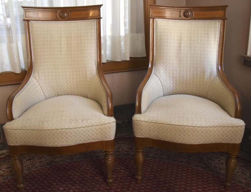 Een paar fauteuils van licht gevernist mahoniehout met witte stoffering.