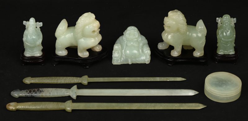 Een lot van 8 Chinese gesculpteerde beeldjes uit jade, bestaande uit fo honden, Boeddha’s, zwaardjes, etc.