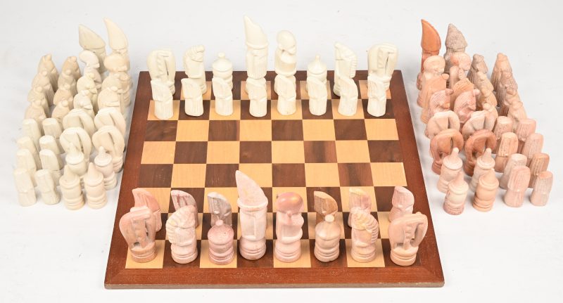 Een schaakbord met 3 sets speelstukken.