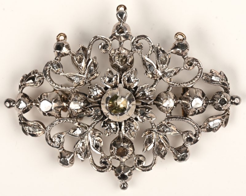 Een zilveren broche met bladmotief en diamanten oude slijp met een gezamelijk gewicht van +- 0,90 ct. Einde 19eeuw.