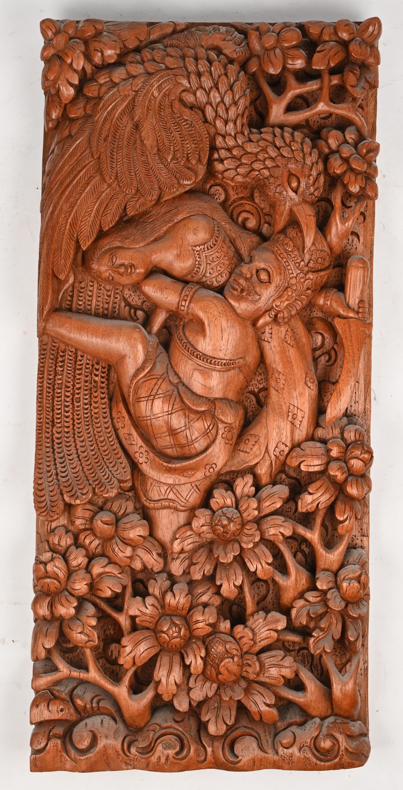 Een Oosters gesculptuurd houten paneel met mytisch decor in het snijwerk.