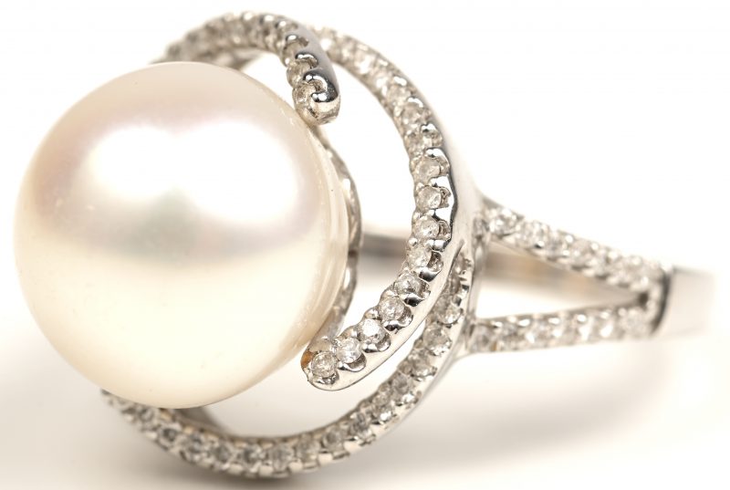 Een 18kt witgouden ring bezet centrale parel en met briljanten met een gezamenlijk gewicht van 0,36 ct.