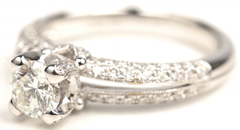 Een 18kt witgouden ring bezet met centrale briljant 0,60 ct. F VS1 en bezet met briljanten met een gezamenlijk gewicht van 0,58 ct.