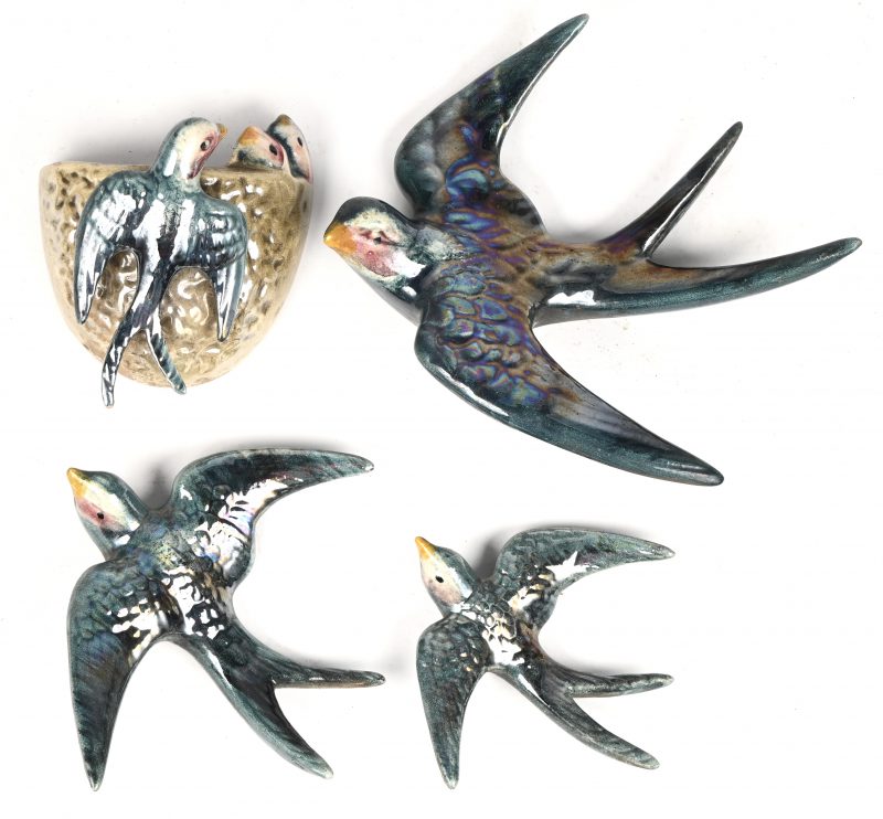 Een set van 6 vintage keramieken muurdecoratie zwaluwen waarvan 3 vliegend en 1 hangend aan zijn/haar nestje en nog eens 2 in hetzelfde nestje.