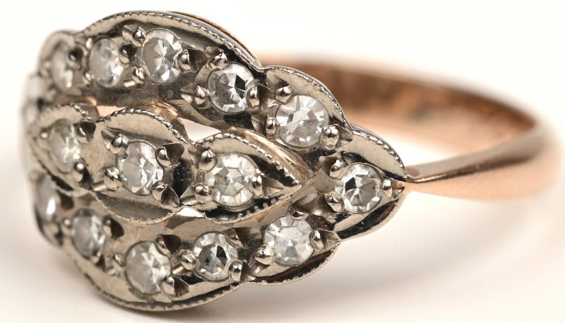 Een 14 kt wit en geelgouden ring bezet met bezet met diamanten met een gezamenlijk gewicht van +- 0,45 ct.