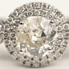 Een 18 kt witgouden ring bezet met een centrale diamant van +- 1,10 ct. en kleine briljantjes met een gezamenlijk gewicht van +- 0,50 ct.
