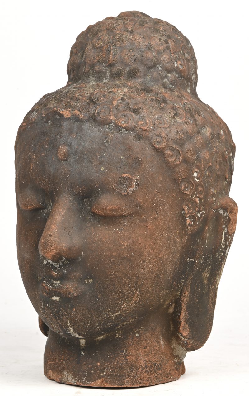 Een terracotta beeld van een Boeddha hoofd.