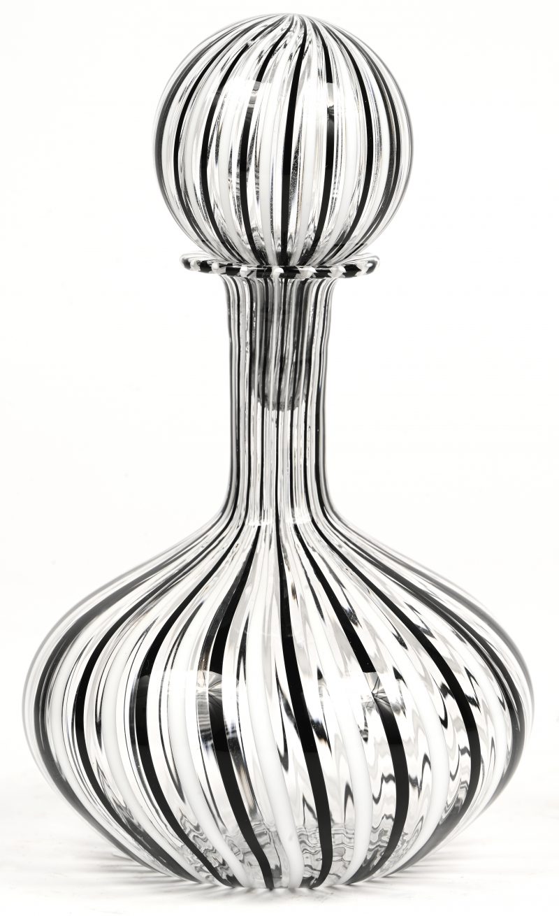 Een Muranoglas karafje, kleurloos met witte en zwarte lijnen.