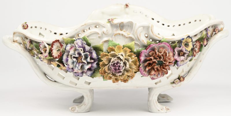 Een polychroom porseleinen mand op vier poten. Met handgeschilderd decor en rijkelijk uitgewerkte bloemen. Gemerkt onderaan, en genummerd.