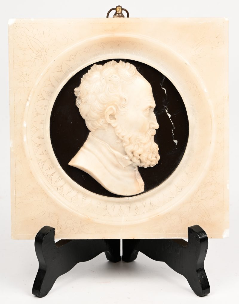 Een marmeren plaquette met profiel portret in het reliëf. Barst in kadrage onderaan.