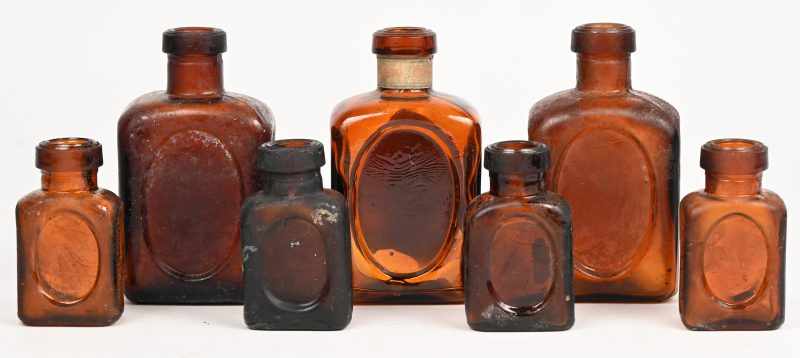 Een lot vintage amberkleurig glazen OXO bouillon flesjes.