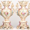 Een paar Frans polychrome vazen met romantisch en floraal decor. 19e eeuws. 1 vaas met breukschade aan de voet.