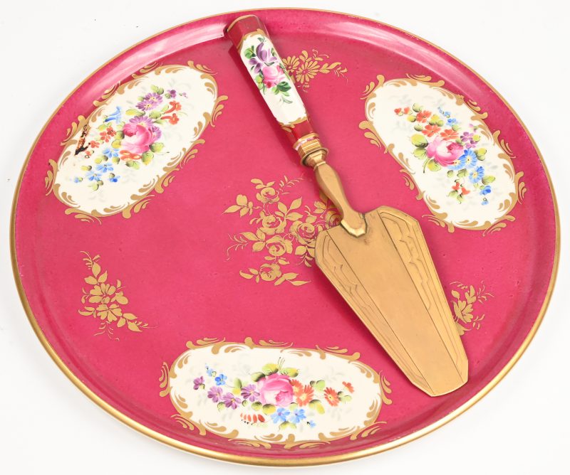 Een Frans porseleinen taartbord met koperen taartschep. Handbeschilderd floraal decor met vergulde elementen.