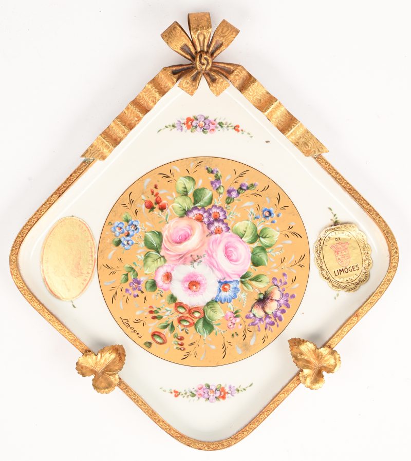 Een porceleinen asbak van Limoges met beschilderd decor en vergulde rand en elementen.