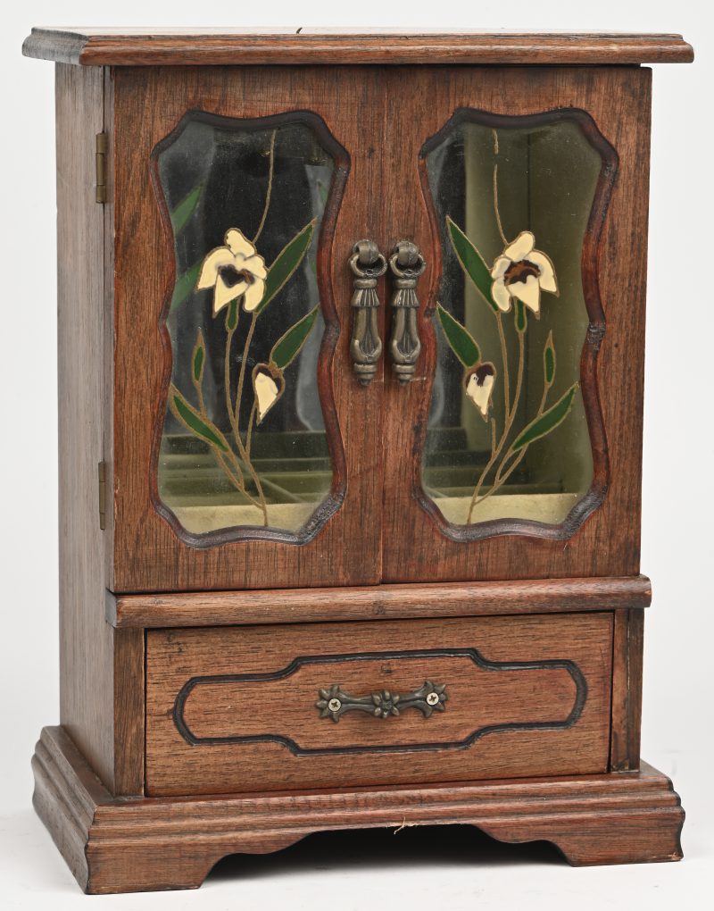 Een houten juwelenkastje met 2 deurtjes en schuifje. Floraal decor op het glasraam.