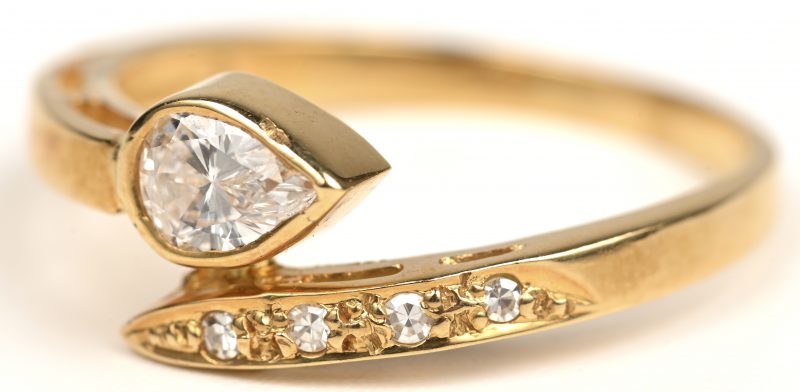 Een 18 kt geelgouden ring bezet met kleine en een peervormige briljant.