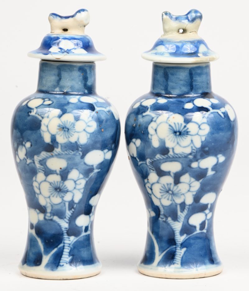Een paar blauw wit Chinees porseleinen dekselvaasjes met fo hondjes, waarop restauratie zichtbaar.