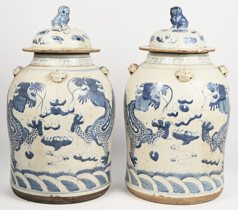 Een paar Chinese porseleinen dekselvazen met blauw en witte versiering van draken.