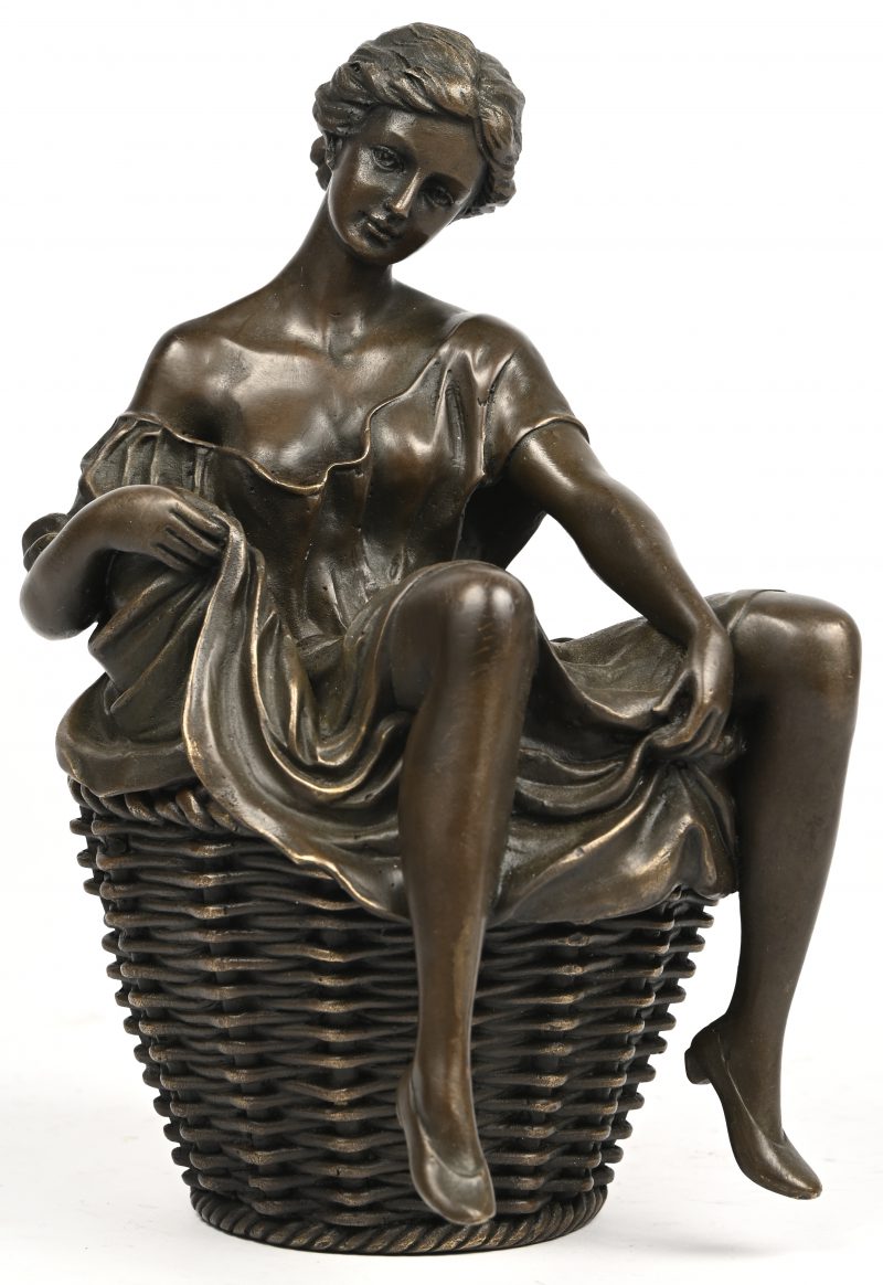Een bronzen beeldje van een uitdagende vrouw in een wasmand.