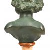 Een groen gepatineerde bronzen buste van een jongentje op marmeren sokkel, achteraan getekend Nelson.