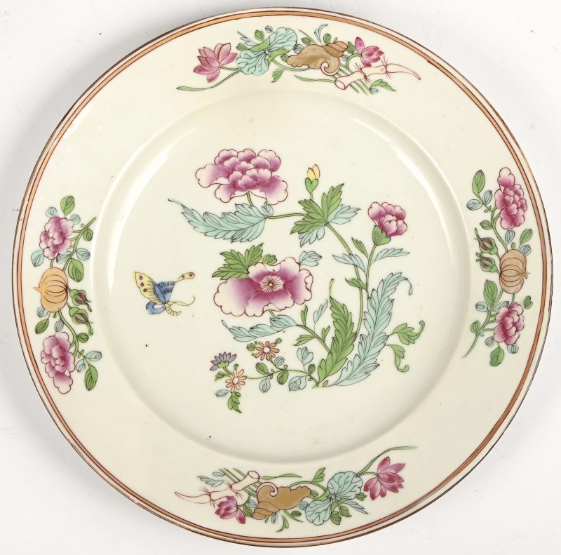 Een bord van veelkleurig porselein met een famille rose decor van pioenen met vergulde details. Symbolen onderaan de vleugel.