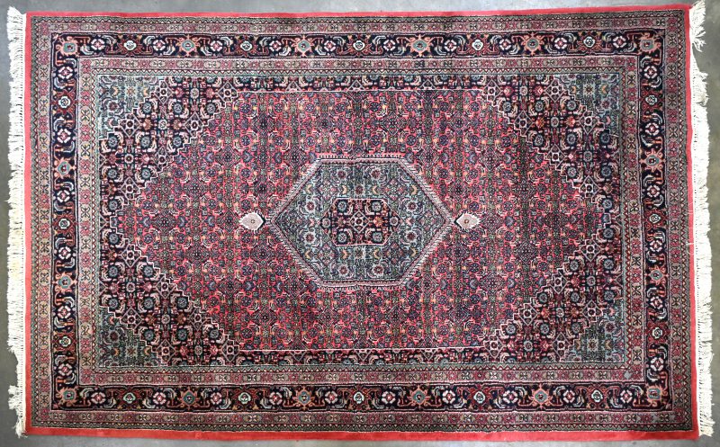 Een groot Perzisch handgeknoopt tapijt.
