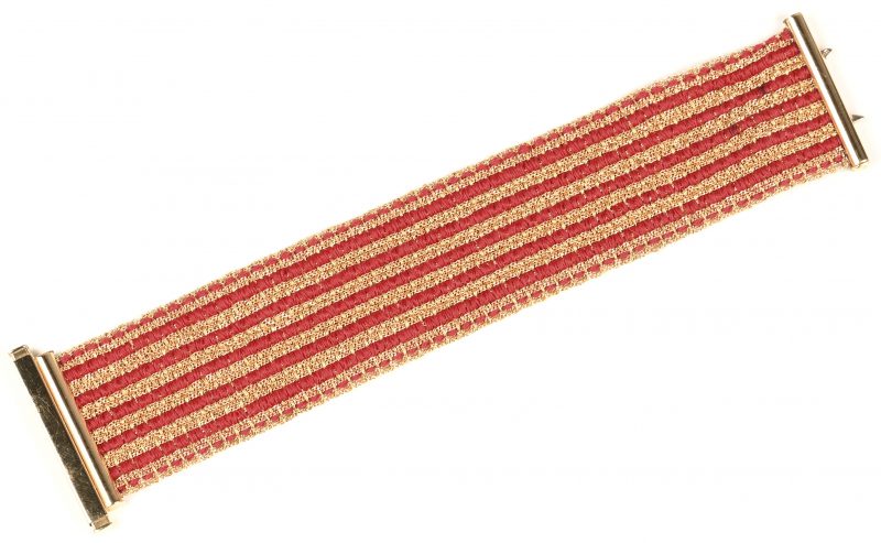 Een armband met 18 kt geelgouden tussenstukken en rode geweven stof.