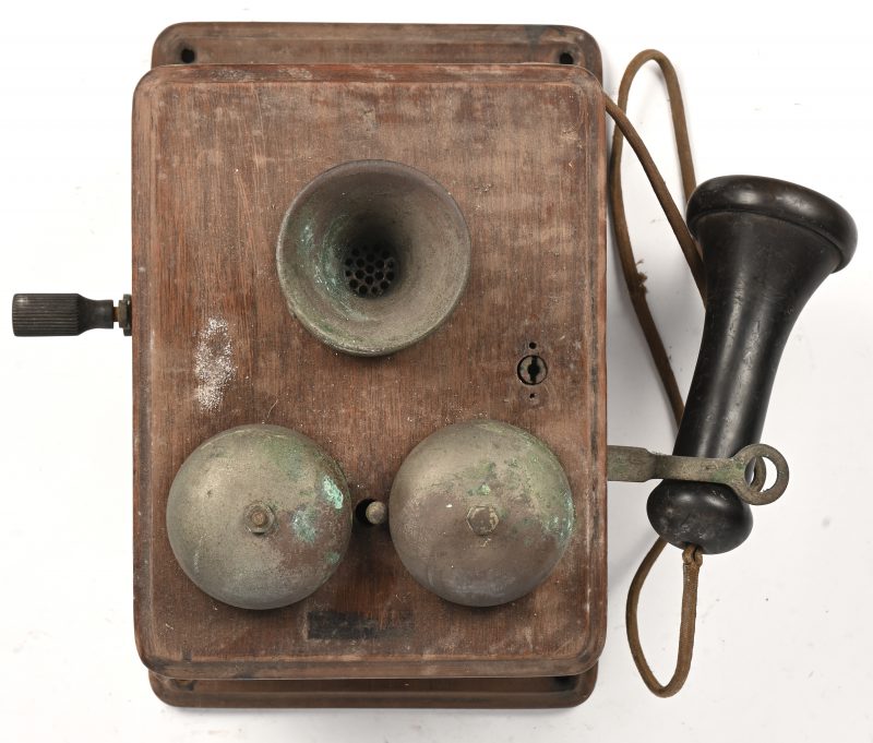 Een antieke wandtelefoon, Bell Telephone, Anvers, Belgique in hout, bakeliet en metaal. Ca 1900.