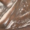 Bronzen profiel met laurierkrans op houten plaquette, draagt handtekening Jul Dillens.