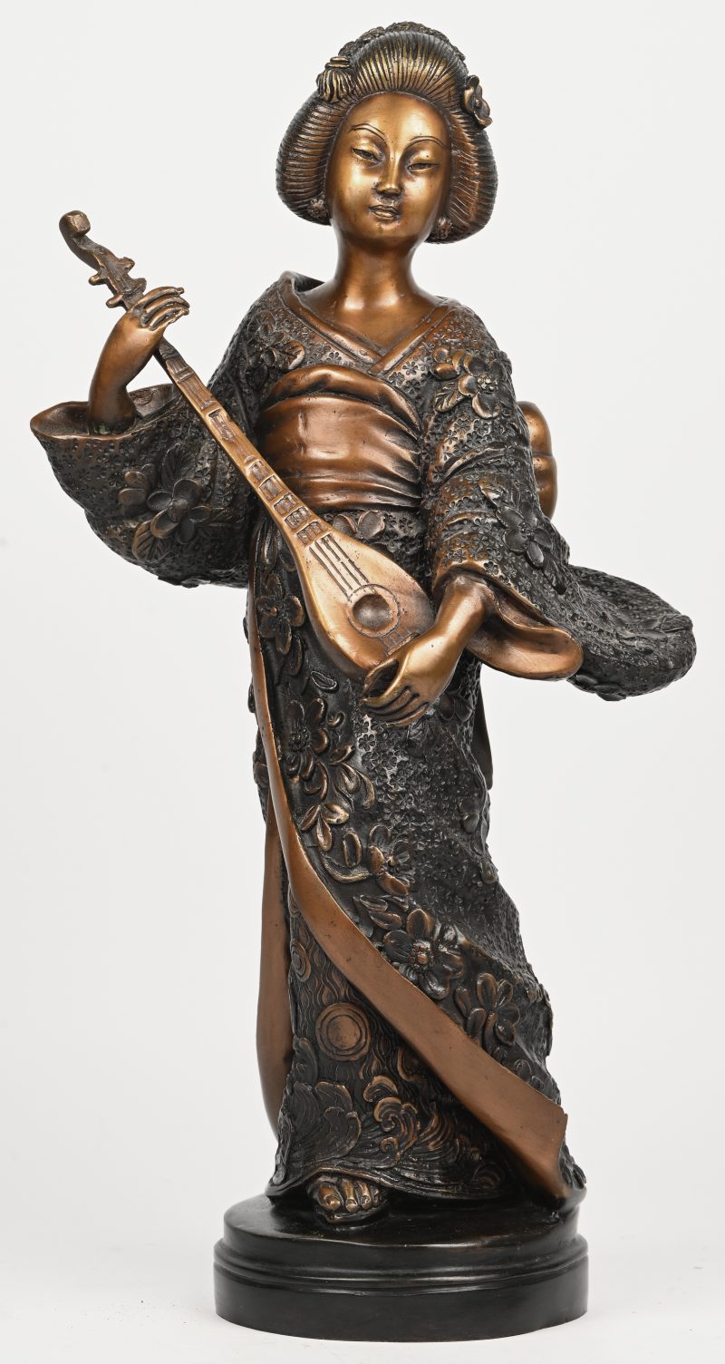 Een bronzen beeld van een Geisha met snaarinstrument.