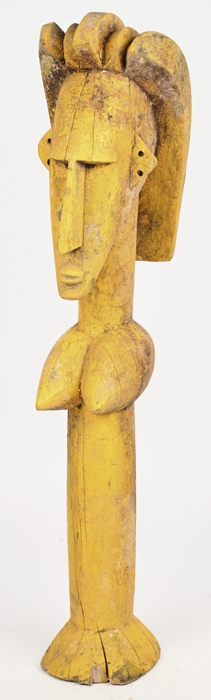 Een geel geschilderd beeld van een vrouw. West-Afrika.