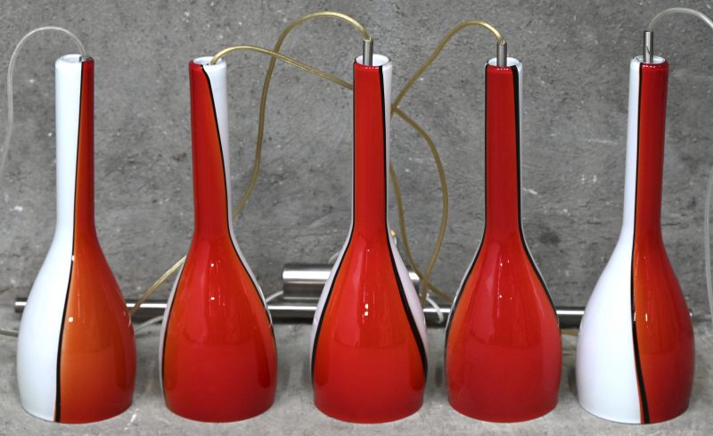 Een moderne hanglamp met vintage look, 3 lichtpunten en 5 meerkleurig rood, wit, zwart glazen coupes, waarvan 2 reserve.