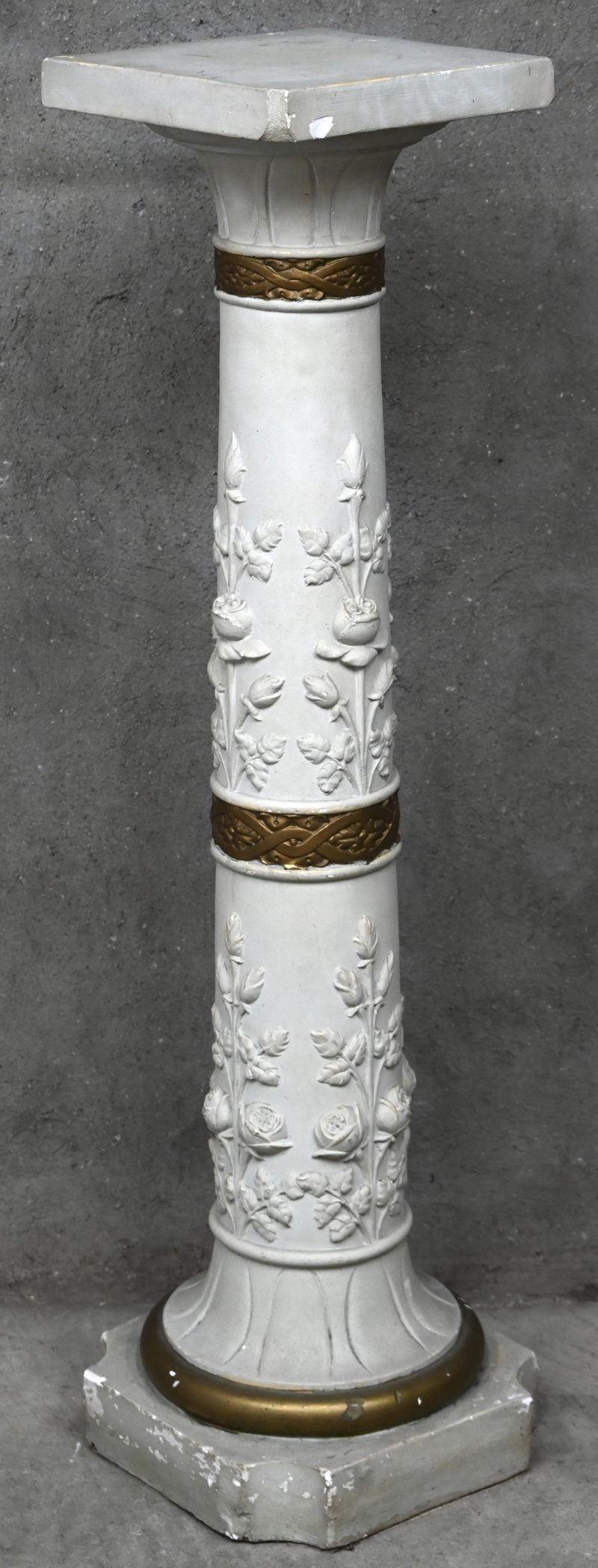 Een uit gips gesculpteerde zuil pilaar als piedestal met rozen ornamenten en vergulde details. Schilferschade aanwezig.