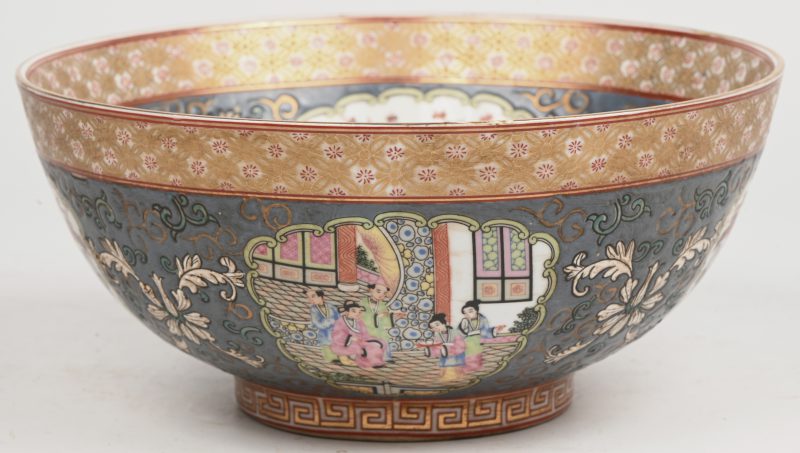 Een Chinees porseleinen kom, famille rose met diverse figuren en floraal in het decor en reliëf. Onderaan gemerkt.