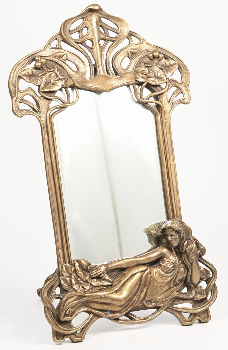 Een brons gesculpteerde Art Nouveau spiegel met liggende vrouwfiguur aan de bodem.