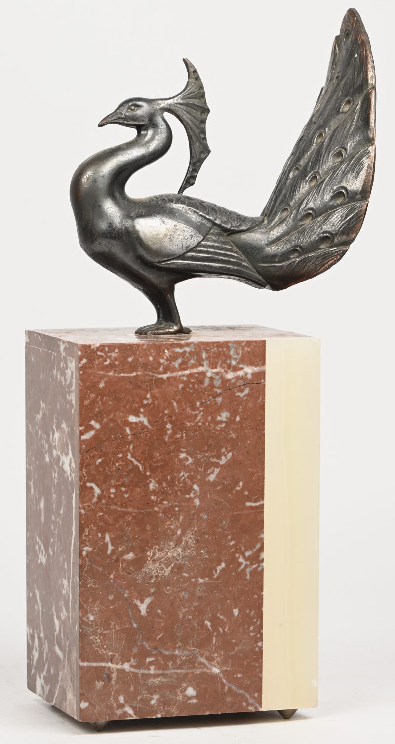 Een Art-deco beeldje van een pauw in kunstbrons op een marmeren sokkel.