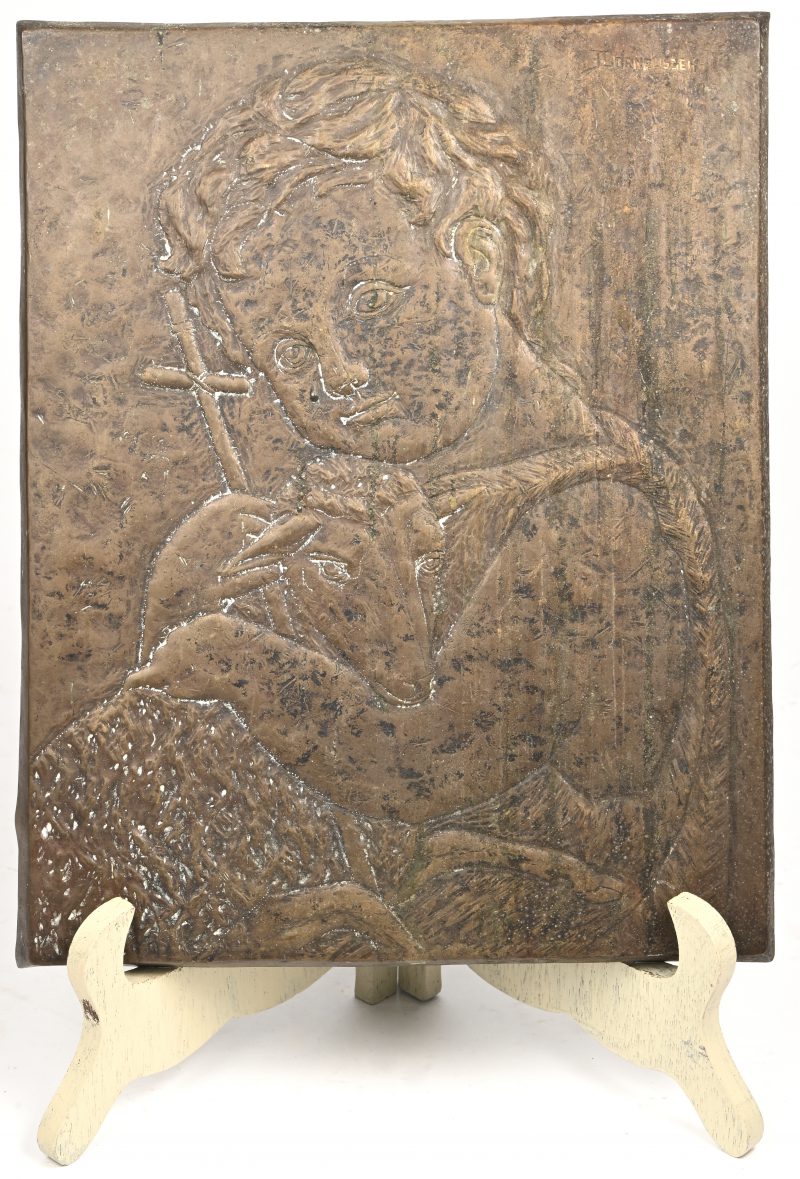 “Kind met lam”. Een Dinanderie plaquette met tekening in het reliëf. Bovenaan gesigneerd.