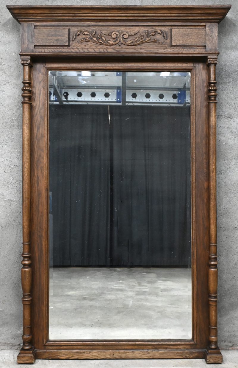 Een grote geslepen Mechelse spiegel in houten gesculpteerd kader.