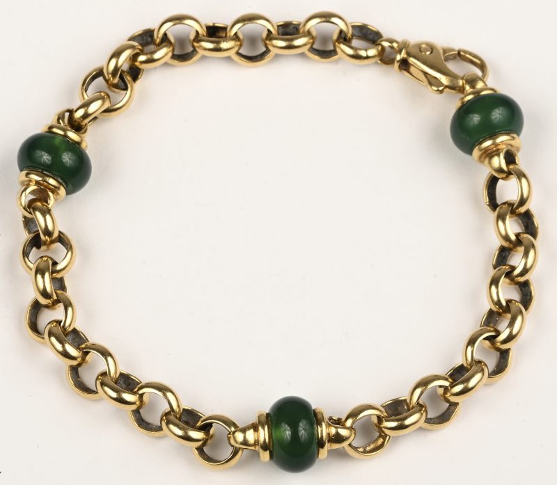 Een 18 kt geelgouden schakelarmband met drie tussenstukken van jade.