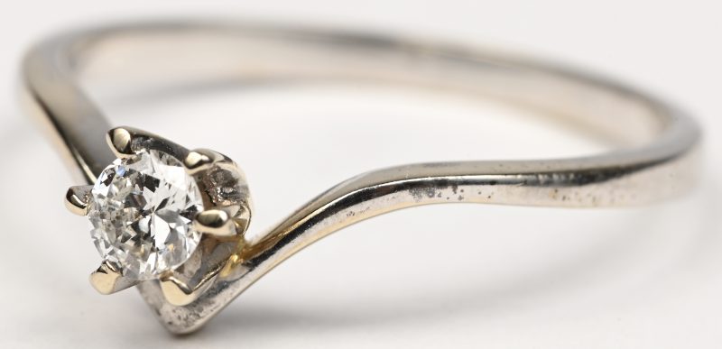 Een 18 kt witgouden ring bezet met solitair briljant van +- 0,15 ct.