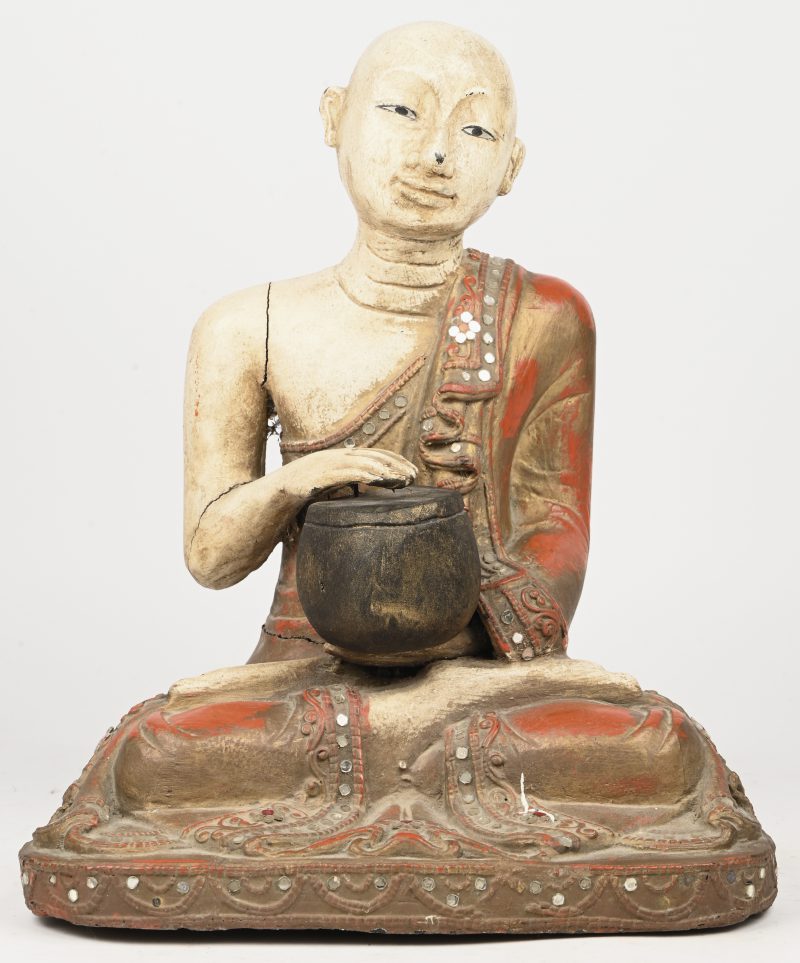 Een polychroom houten Buddha beeld die de trommel bespeeld.