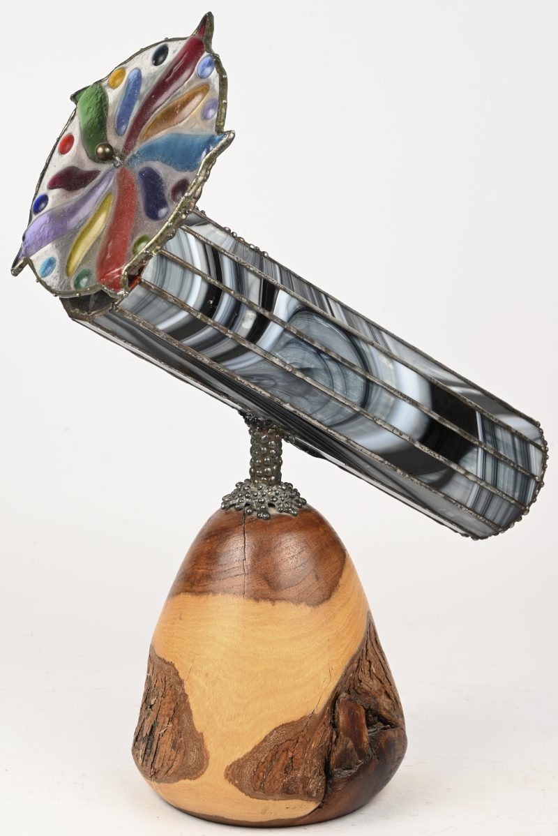 Een caleidoscoop vervaardigd uit glas in lood op een massief houten voet.