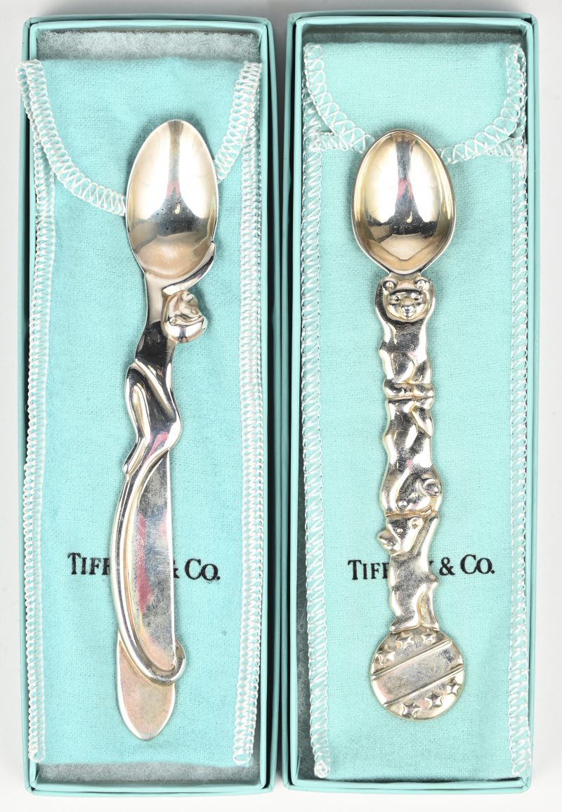 Een lot van 2 zilveren lepeltjes van Tiffany & Co, de ene met de afbeelding van een aapje, de andere met 3 acrobatische aapjes.