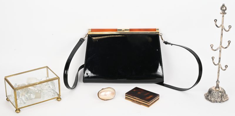 Een vintage lot ‘for the ladies’, bestaande uit een zwart handtasje in kunstleder, een verzilverde juwelenhouder, een poederdoosje, een display-kastje met los deksel gevuld met oude karafdoppen en een klein portemonneetje vervaardigd uit een schelp.