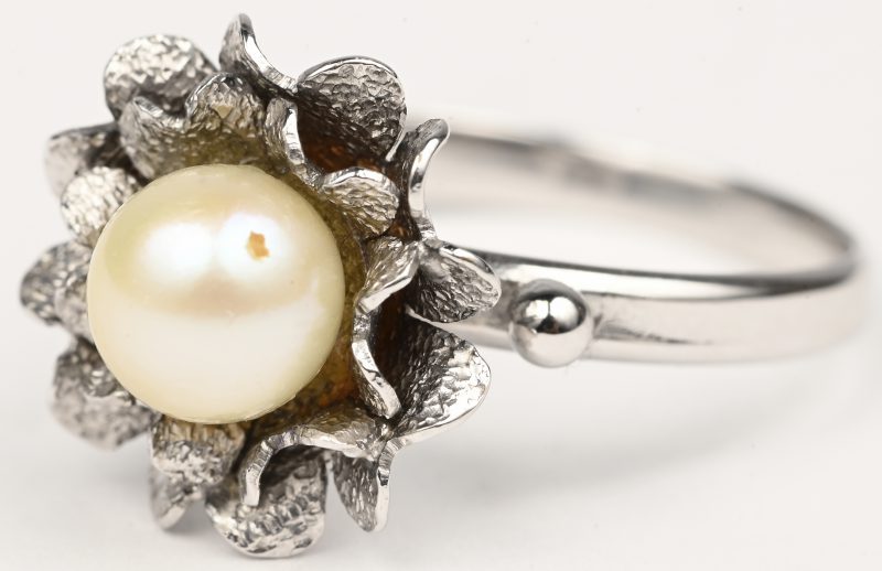 Een 18 kt witgouden bloemvormige ring bezet met een parel.