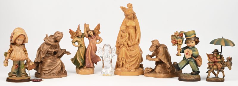 Een lot van 7 fijn gesneden beeldjes, houtsnijwerk van het Italiaanse merk Anri. Bestaande uit: Maria met Jezus, 2 engelen, een meisje met mand, een jongen met bloemen, kinderen op een ezel en Jozef en Maria uit de kerststal. Toegevoegd een glazen engeltje.