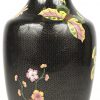 Een cloisonné vaas met zwarte achtergrond en een decor van bloemen, bladeren en een vlinder.