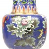 Een cloisonné vaas met blauwe achtergrond en een decor van bloemen.