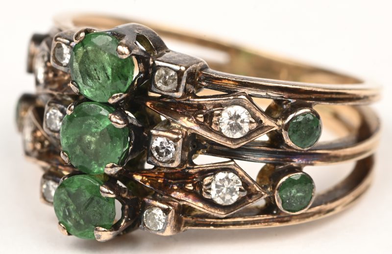 Een 18 kt geelgouden ring bezet met briljanten met een gezamenlijk gewicht van +- 0,20 ct. en een smaragden met een gezamenlijk gewicht van +- 0,70 ct.
