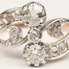 Een 18 kt wit en geelgouden ring bezet met twee briljanten en diamanten oude slijp met een gezamenlijk gewicht van +- 0,80 ct.